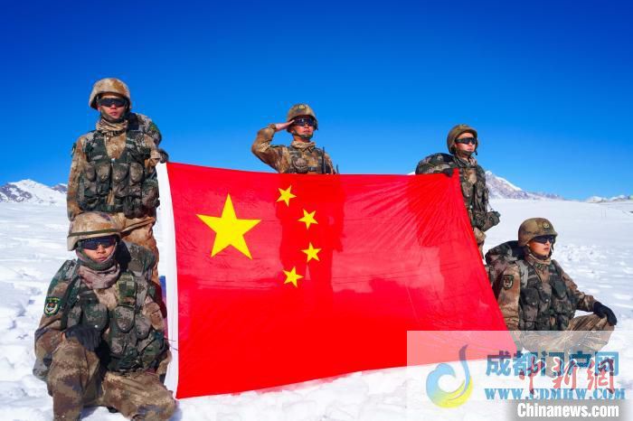 官兵在山顶与国旗合影。 西藏山南军分区某团供图 官兵在山顶与国旗合影。 西藏山南军分区某团供图