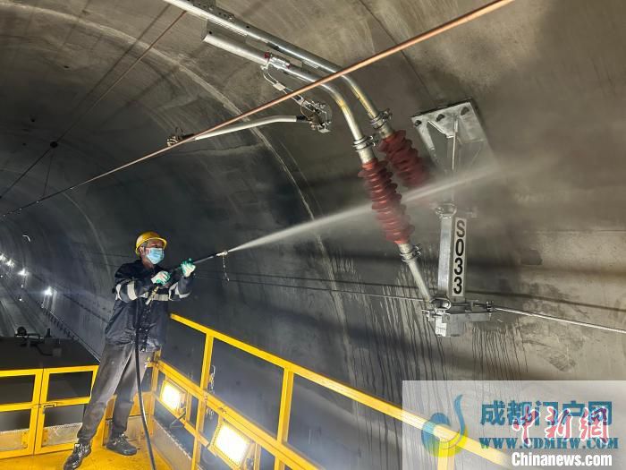 图为作业人员用水枪冲洗接触网绝缘子。 莫凤岩 摄 图为作业人员用水枪冲洗接触网绝缘子。 莫凤岩 摄